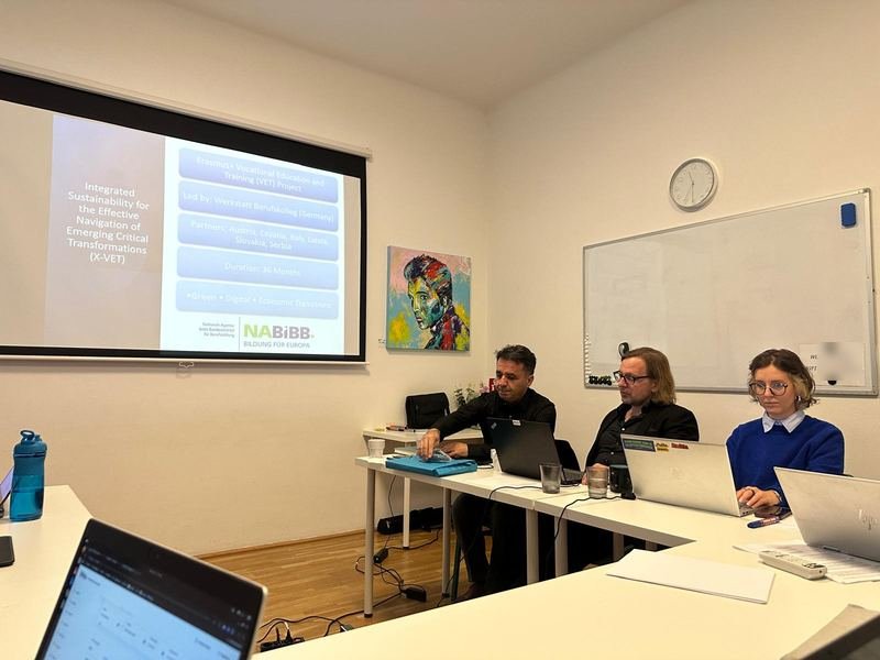 The X-VET project presentation on the screen, with partners at the table